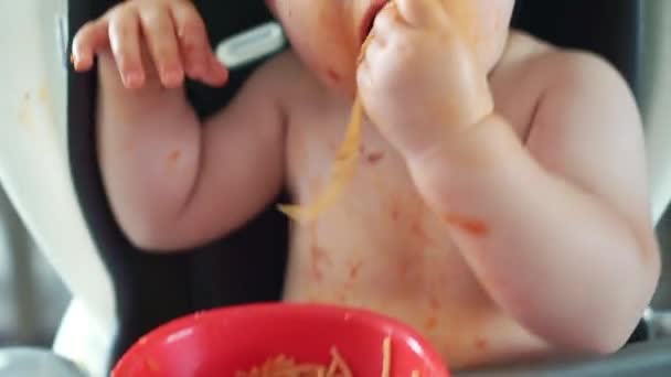 Niña, comer espaguetis para el almuerzo y hacer un lío en casa en la cocina — Vídeos de Stock