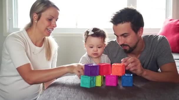 Lycklig far, mor och liten dotter leker med leksaksblock hemma — Stockvideo