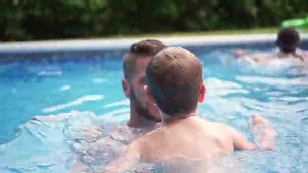 Lindo niño aprendiendo a nadar con los padres en la piscina — Vídeos de Stock