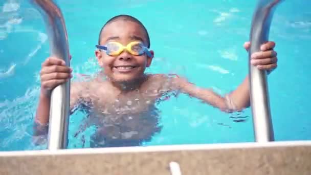 Portrait de garçon ayant du bon temps dans la piscine — Video