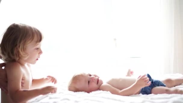 Dítě v posteli se svým bratrem syn dává polibek — Stock video