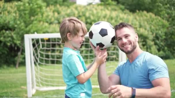 Uomo con bambino che gioca a calcio fuori sul campo — Video Stock