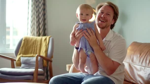 Junger Vater mit kleiner Tochter auf Stuhl zu Hause — Stockvideo