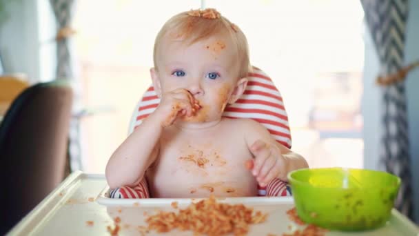 Kleine baby eet spaghetti diner en maakt er een puinhoop van — Stockvideo