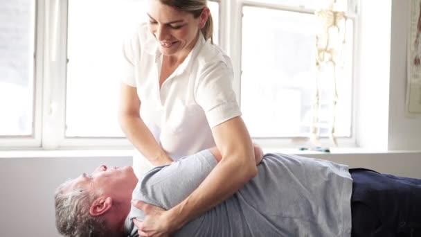 Ein moderner Reha-Physiotherapeut mit Seniorenkunden — Stockvideo