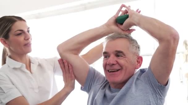 Ein moderner Reha-Physiotherapeut mit Seniorenkunden — Stockvideo