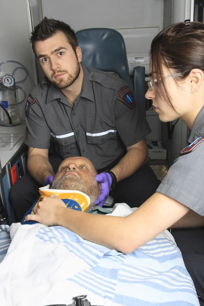 Professionele paramedici geven onbewuste jonge vrouw EHBO — Stockfoto