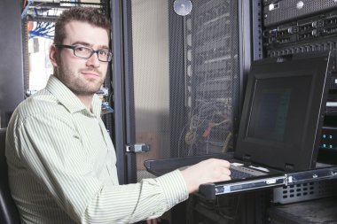 A happy worker technician at work with computer. clipart