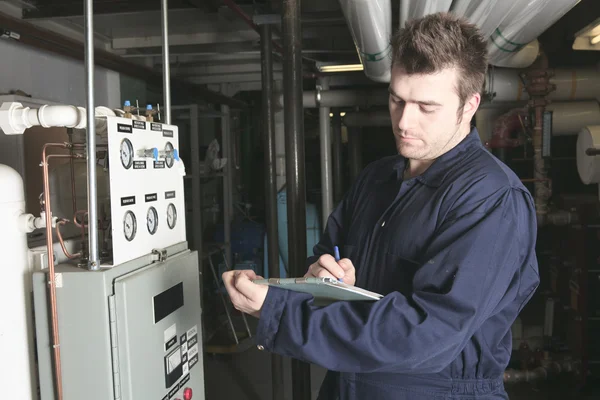 Maintenance engineer checking technical data of heating system e — Stock Photo, Image