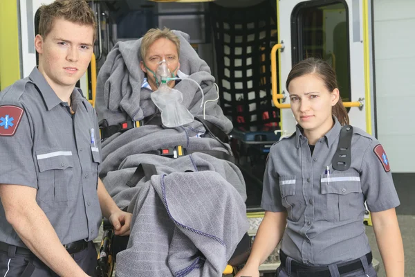 Empleado paramédico con ambulancia en segundo plano . — Foto de Stock