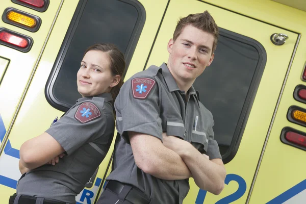 Funcionário paramédico com ambulância em segundo plano . — Fotografia de Stock