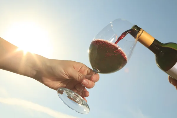 Ein Paar trinkt draußen eine Flasche Rotwein — Stockfoto