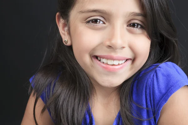 Ein kolumbianisches kleines Mädchen im lustigen Look vor schwarzem Hintergrund Stockbild