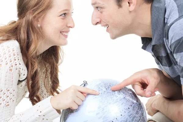 Jeune couple excité planifiant leurs vacances tenant un globe a — Photo