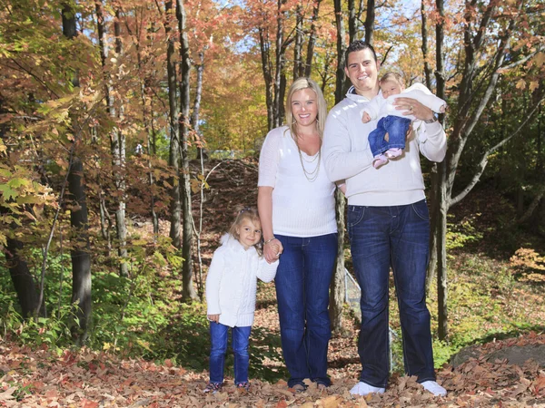 A Family enjoying golden leaves in autumn park — Stock Photo, Image