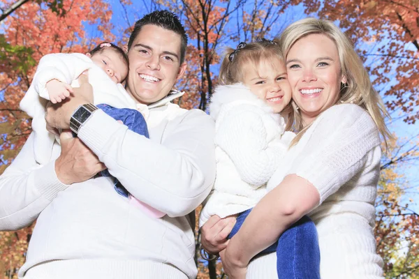 A Family enjoying golden leaves in autumn park — Stock Photo, Image