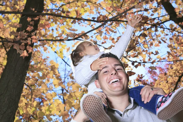 Una familia disfrutando de hojas doradas en el parque de otoño —  Fotos de Stock