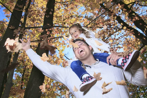 A Family enjoying golden leaves in autumn park — Stock Photo, Image