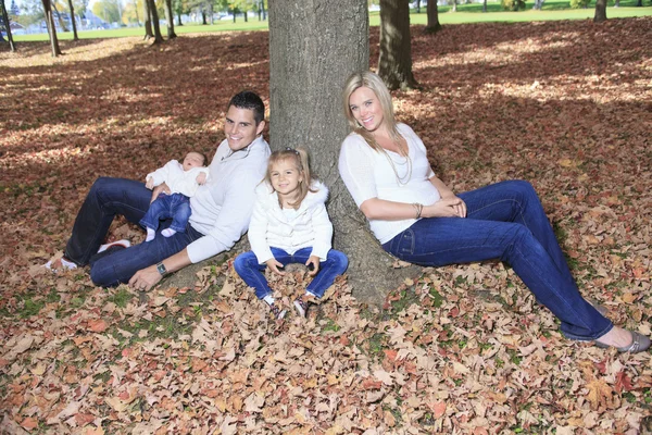 A Family enjoying golden leaves in autumn park — Stock Photo, Image