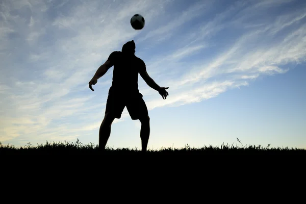 A soccer player play in back lit day time