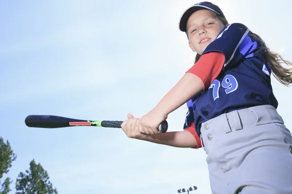 Una chica de béisbol bateadora sobre un cielo azul —  Fotos de Stock