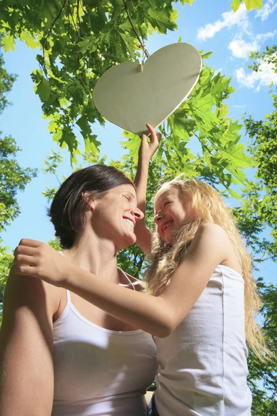 Ein kleines Mädchen versucht Herz auf einem Baum zu fangen — Stockfoto