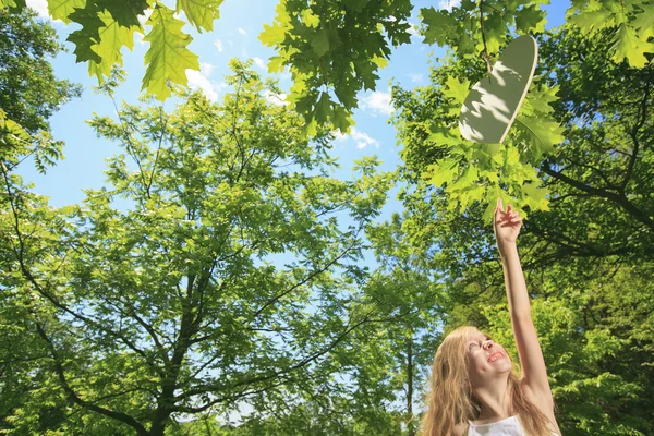 Ein kleines Mädchen versucht Herz auf einem Baum zu fangen — Stockfoto