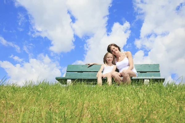 Una donna con il suo bambino seduto sulla panchina — Foto Stock