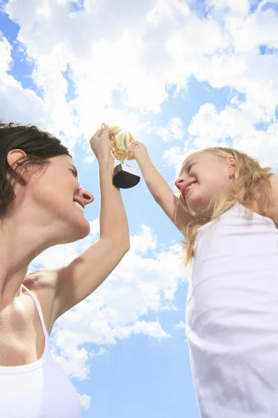 A Happy mother and daughter holding a trophy high up — Stock Photo, Image