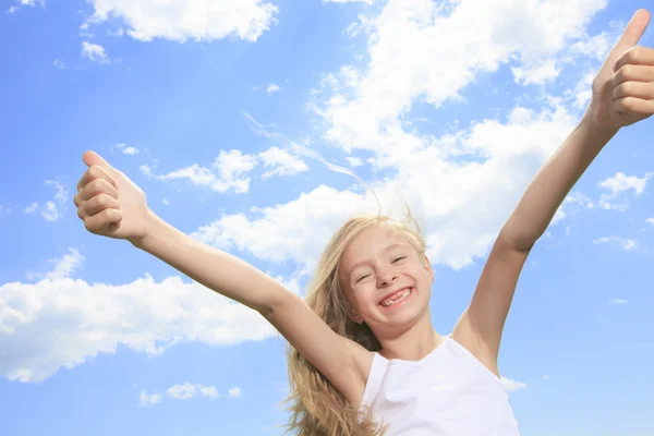 Una bambina sorridente in bianco t-shirt bianca mostrando pollici in su o — Foto Stock