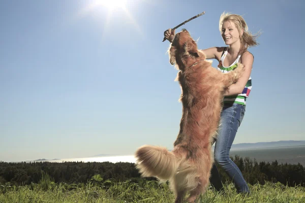 Chica divertida juega con el perro fuera —  Fotos de Stock