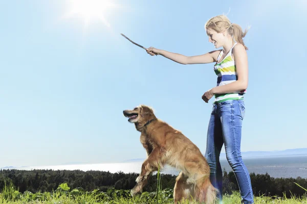 Funny girl plays with the dog outside — Stock Photo, Image