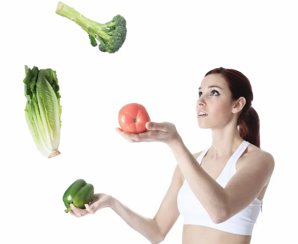 Женщина жонглирует овощами — стоковое фото