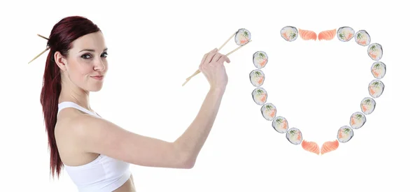 Молода жінка їсть суші на білому тлі — стокове фото