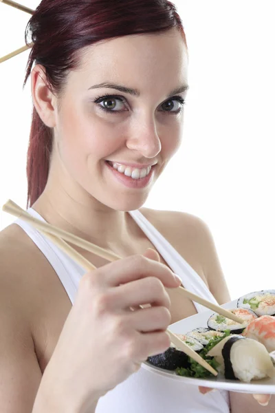 Mujer joven comiendo una pieza de sushi sobre un fondo blanco —  Fotos de Stock