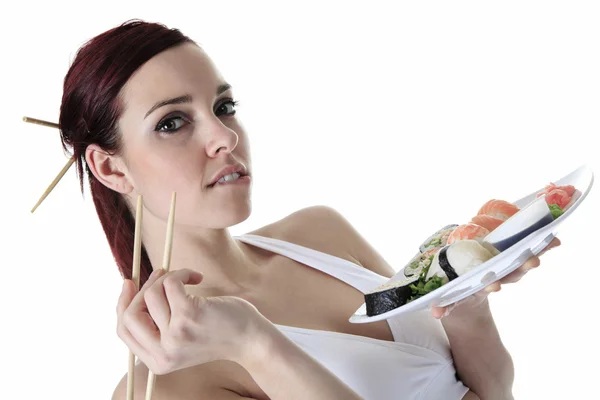 Jeune femme mangeant un morceau de sushi sur un fond blanc — Photo