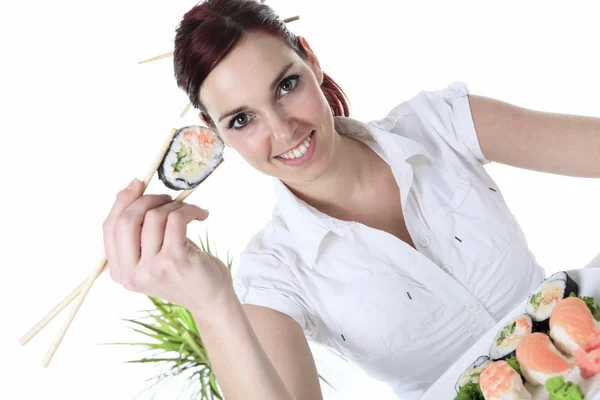 Mujer joven comiendo una pieza de sushi sobre un fondo blanco —  Fotos de Stock