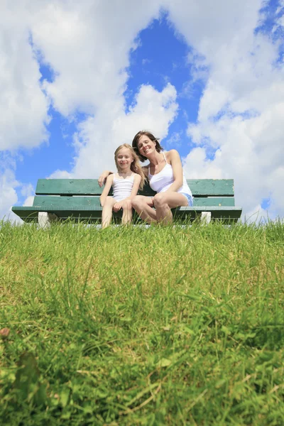 A woman with his child sitting on the bench Royalty Free Stock Photos