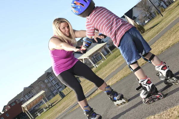 Active family - mother and kid having fun, rollerblading outdoor — Stock Photo, Image