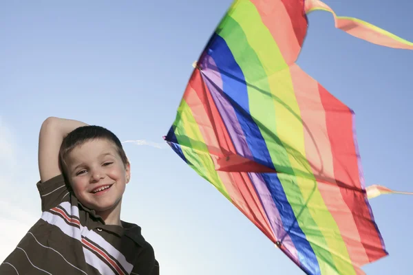 Un ragazzo che gioca con è aquilone con il cielo sullo sfondo — Foto Stock