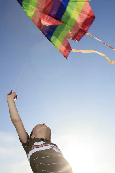 一个男孩玩是风筝与天空的背景 — 图库照片