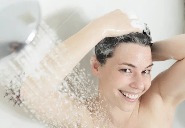 Ducha mujer. Feliz mujer sonriente lavándose el hombro duchándose en —  Fotos de Stock