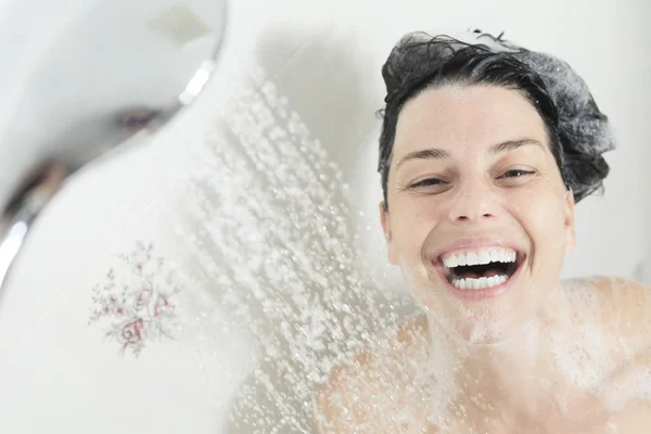 Mulher do chuveiro. Feliz sorrindo mulher lavando ombro tomando banho em — Fotografia de Stock