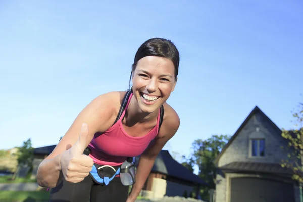 Une femme faisant du jogging dans un lieu urbain avec une maison en arrière-plan — Photo