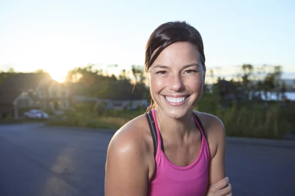 Una donna che fa jogging in un luogo urbano con la casa sullo sfondo — Foto Stock