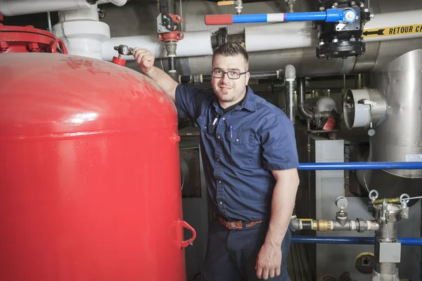 Ein guter Servicetechniker, der an einem Maschinenraum arbeitet — Stockfoto