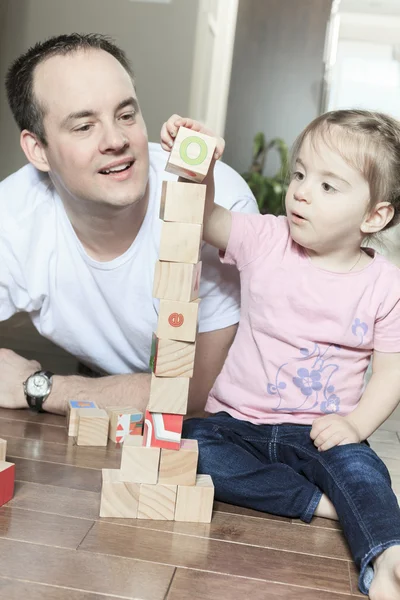 Relajados padre e hija jugando con bloques de construcción en madera —  Fotos de Stock