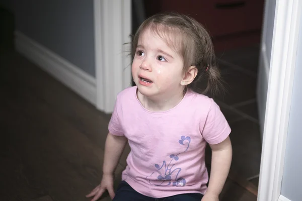 Retrato de una niña triste parada cerca de la pared durante el día — Foto de Stock