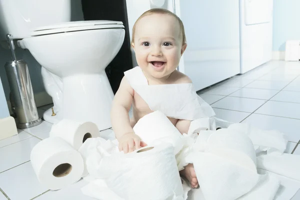 Peuter scheurt wc-papier in de badkamer — Stockfoto