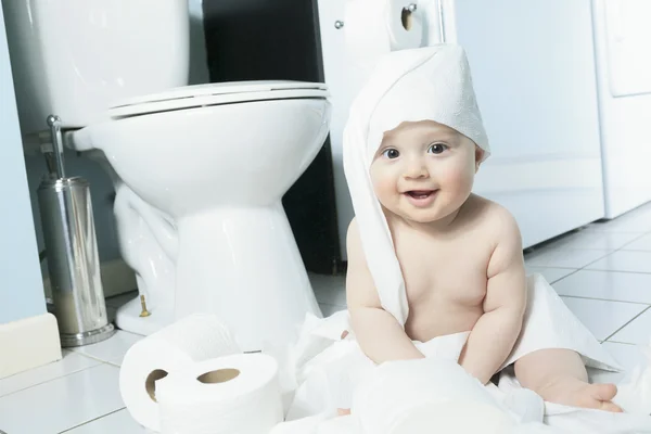 Peuter scheurt wc-papier in de badkamer — Stockfoto